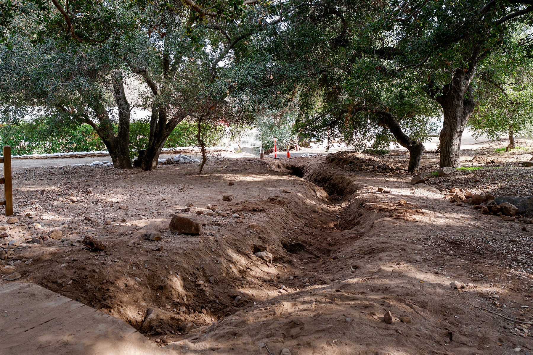 Dry creek bed dug out in a natural setting surrounded by trees