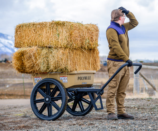 Warrior cart stacked with hay bales. A man easily holds the handle up with one hand.